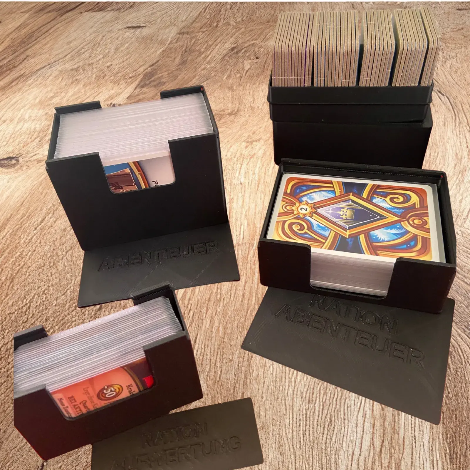 Offene Abenteuer- und Nation-Abenteuer-Kartenbox mit gesleevten Karten, dahinter die Pappplättchenbox